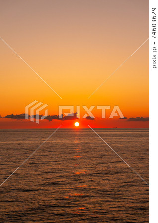 フェリーから眺める水平線に沈む赤く燃える夕日 74603629