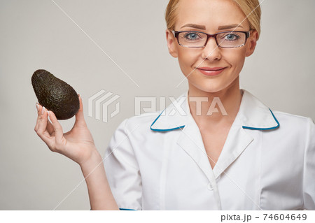 nutritionist doctor healthy lifestyle concept - holding organic avocado fruit nutritionist doctor healthy lifestyle concept - holding organic avocado fruit 74604649