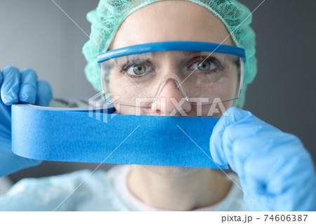 Woman doctor sealing her mouth with blue tape 74606387