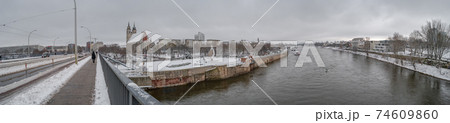 Panoramic view over Magdeburg historical downtown in Winter with icy trees and snow during foggy day and dramatic sky, Germany. 74609860