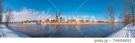 Panoramic view over Magdeburg historical downtown in Winter with icy trees and snow during sunrise in the morning with warm illumination and blue sky, Germany. Panoramic view over Magdeburg historical downtown in Winter with icy trees and snow during sunrise in the morning with warm illumination and blue sky, Germany. 74609891