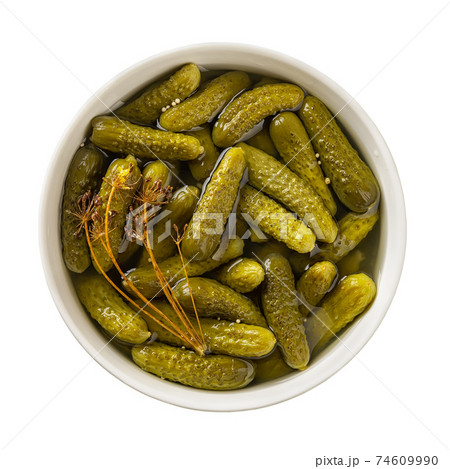 Delicious pickled cornichons in a ceramic bowl isolated on white background. 74609990