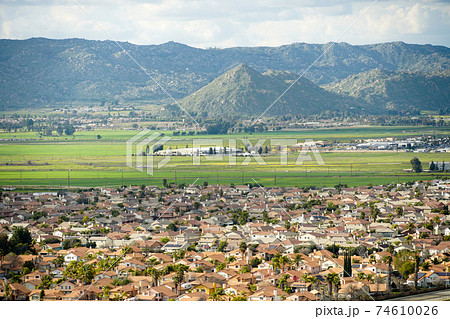 Aerial view suburban neighborhood with identical wealthy villas next to each other with mountain behind.  74610026