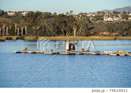 Wood pier with pedal boat and small boat.  74610031