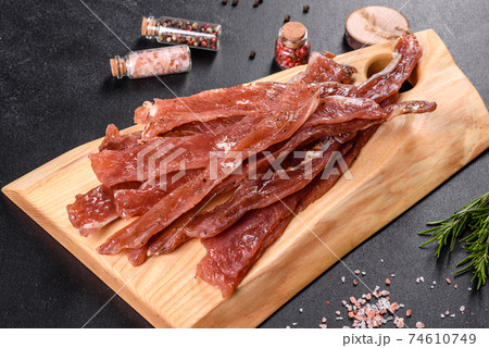 Tasty hearty meat salted and dried with pieces of spices and herbs Tasty hearty meat salted and dried with pieces of spices and herbs 74610749