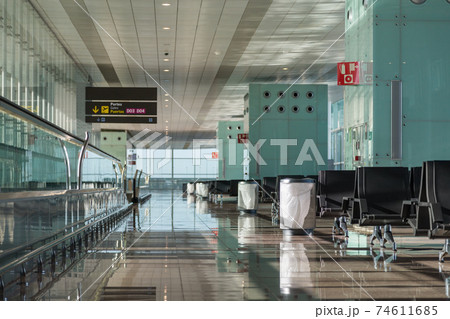 Empty airport lounge area with seats, moving walkway, trash cans and scoreboard. Empty airport lounge area with seats, moving walkway, trash cans and scoreboard. 74611685