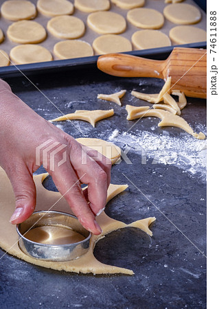 Woman prepares butter cookies at home in the kitchen Woman prepares butter cookies at home in the kitchen 74611888
