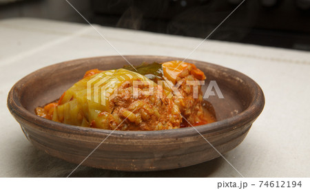 bell pepper stuffed with meat and rice in red tomato sauce on a plate. bell pepper stuffed with meat and rice in red tomato sauce on a plate. 74612194