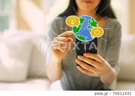 Saving energy concept with woman using a smartphone Saving energy concept with woman using a smartphone 74612435