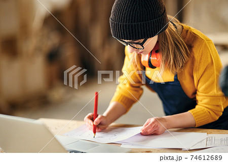 Artisan woman working in carpentry workshop 74612689