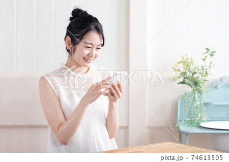 スマホを見る女性(笑顔) スマホを見る女性(笑顔) 74613505