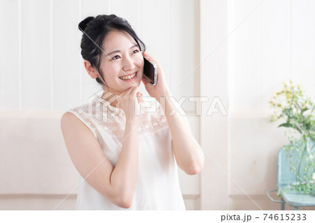 スマホで通話する女性(笑顔) スマホで通話する女性(笑顔) 74615233