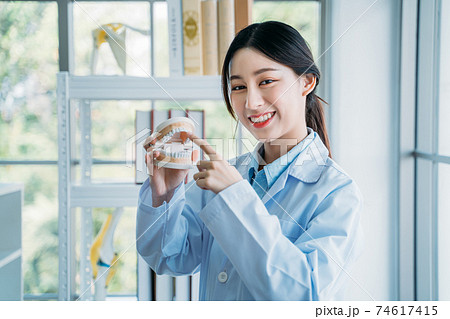 Dental doctor holding false teeth 74617415