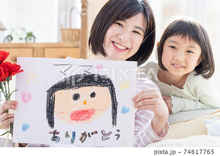母の日カーネーションと似顔絵を貰ったママと女の子のポートレート 74617765