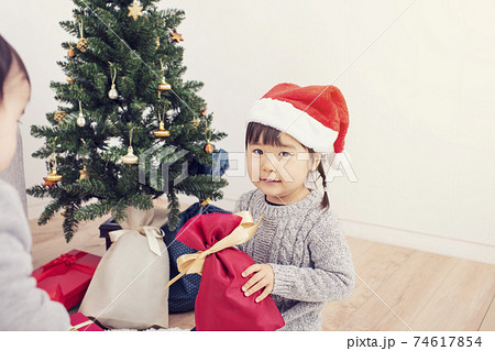 クリスマスプレゼントを開封する女の子の写真素材