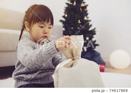 クリスマスプレゼントを開封する女の子の写真素材