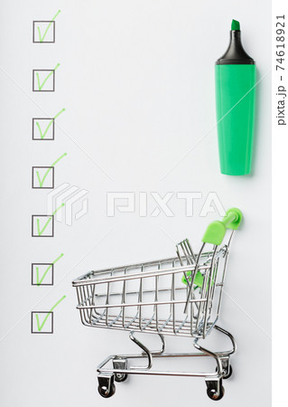 Supermarket Cart and Green Marker Marked on the Checklist Sheet. Supermarket Cart and Green Marker Marked on the Checklist Sheet. 74618921