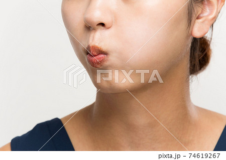 頬を膨らます女性の写真素材