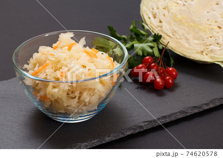 Fermented cabbage with herbs and spices in glass bowl on the black background Fermented cabbage with herbs and spices in glass bowl on the black background 74620578