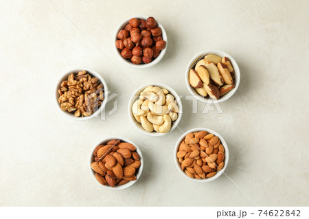 Bowls with different nuts on white textured background, top view Bowls with different nuts on white textured background, top view 74622842