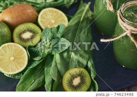 Blended green smoothie with ingredients on the stone board, wooden table 74623498