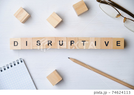Modern business buzzword - disruptive. Top view on wooden table with blocks. Top view. Modern business buzzword - disruptive. Top view on wooden table with blocks. Top view. 74624113