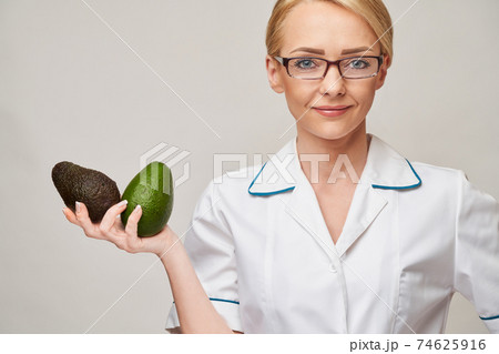 nutritionist doctor healthy lifestyle concept - holding organic avocado fruit nutritionist doctor healthy lifestyle concept - holding organic avocado fruit 74625916