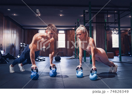 Young couple is working out at gym. Attractive woman and handsom 74626349