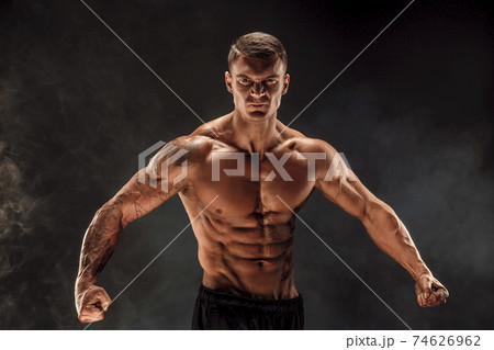 Very brawny guy bodybuilder posing. Beautiful sporty guy male power. Fitness muscled man. Roar 74626962