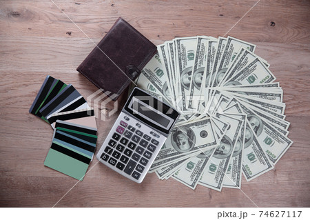 credit cards and dollar bills laid out on a wooden table.business background 74627117
