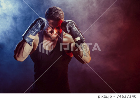 Sportsman boxer fighting on black background with shadow. Copy Space. Boxing sport concept. Sportsman boxer fighting on black background with shadow. Copy Space. Boxing sport concept. 74627340