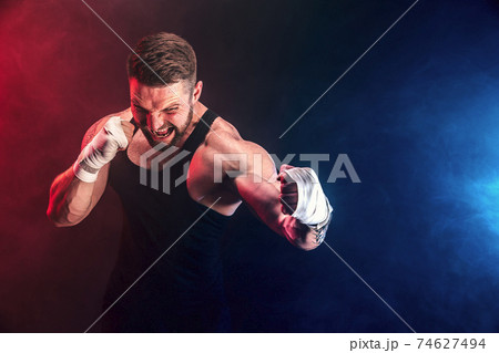 Sportsman muay thai boxer fighting on black background with smoke. Sport concept Sportsman muay thai boxer fighting on black background with smoke. Sport concept 74627494