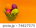 Basket with colorful Easter eggs on yellow background.Copy space. 74627575