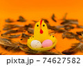 Yellow chick seat on nest with colored plastic Easter eggs on yellow background 74627582