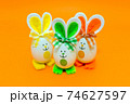 Three Easter eggs with bunny ears on spring yellow background. 74627597