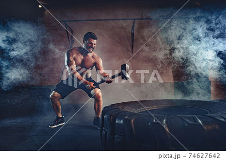 Sports training for endurance, man hits hammer. Concept workout Sports training for endurance, man hits hammer. Concept workout 74627642