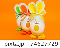 Three Easter eggs with bunny ears on spring yellow background. 74627729