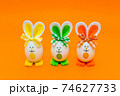 Three Easter eggs with bunny ears on spring yellow background. 74627733