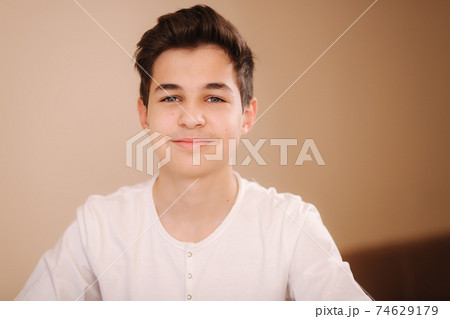 Portrait of young smiled teenage boy in white sweatshirt. Hppy handsome boy after playing games 74629179