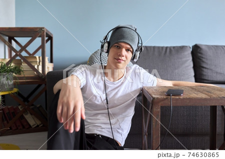 Portrait of hipster teenager in hat with headphones Portrait of hipster teenager in hat with headphones 74630865