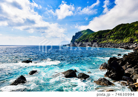 八丈島の海岸と黒砂砂丘と八丈小島の写真素材