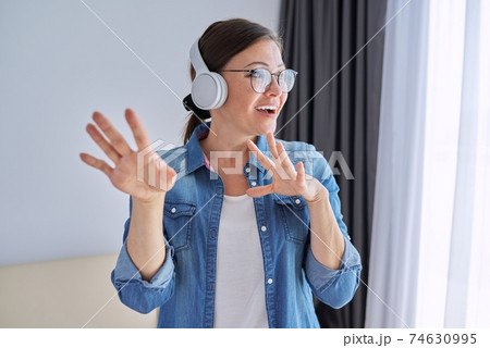 Portrait of mature positive talking woman in headphones Portrait of mature positive talking woman in headphones 74630995