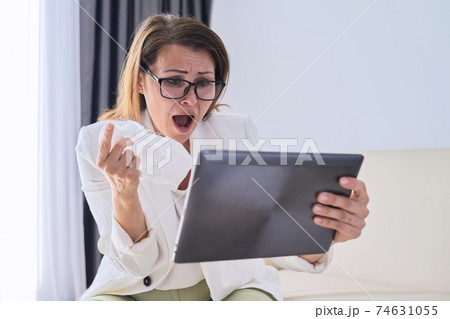 Sick businesswoman sneezing in handkerchief making video call Sick businesswoman sneezing in handkerchief making video call 74631055