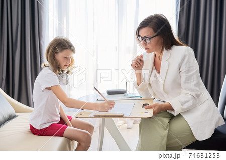 Child psychologist talking to girl kid in office Child psychologist talking to girl kid in office 74631253