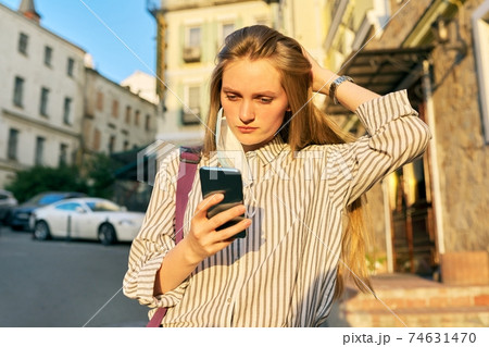 Young business woman office worker in medical protective mask with smartphone 74631470
