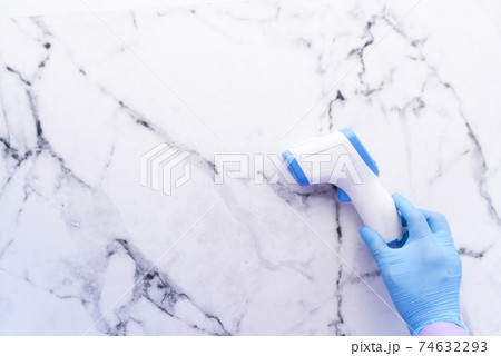 top view of hand holding infrared thermometer to measuring temperature. 74632293