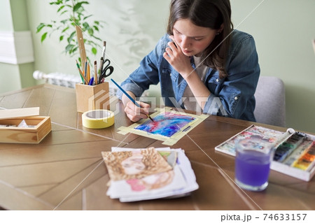 Teenager girl painting with watercolors, sitting at home at the table Teenager girl painting with watercolors, sitting at home at the table 74633157