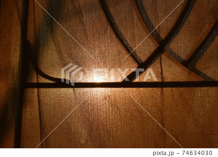 sunlight through old curtain and wrought iron curve on window frame sunlight through old curtain and wrought iron curve on window frame 74634030