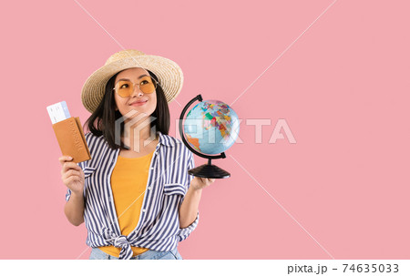 Asian woman holding passport with boarding pass and globe Asian woman holding passport with boarding pass and globe 74635033