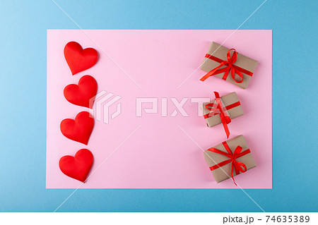 Red hearts, gift box with ribbon on colored background, pink in blue frame, valentine's day greeting 74635389